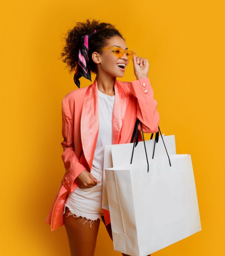 studio-shot-pretty-black-woman-with-white-shopping-bag-standing-yellow-background-trendy-spring-fashionable-look